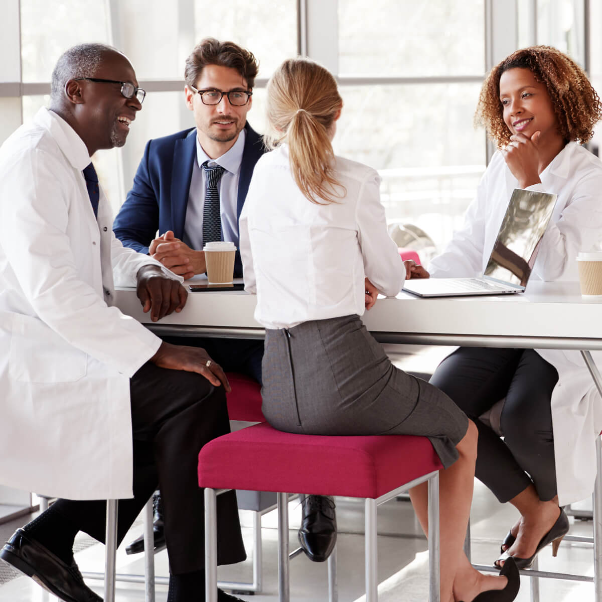 Physicians gather around a table discussing clinical and behavioral health practices