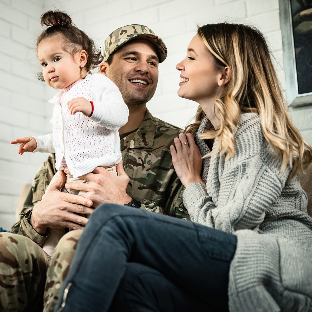 A man in a military uniform reunites with his family.