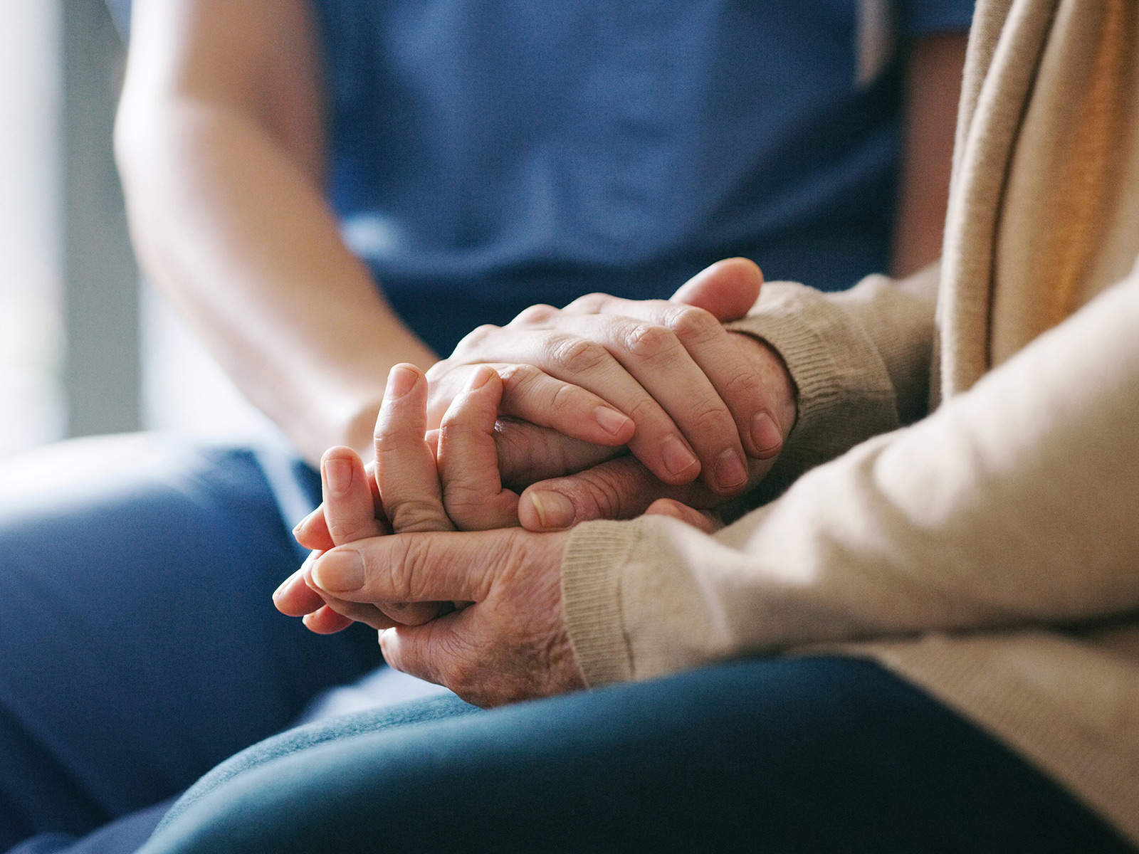 Senior Medicaid member holding hands with a nurse