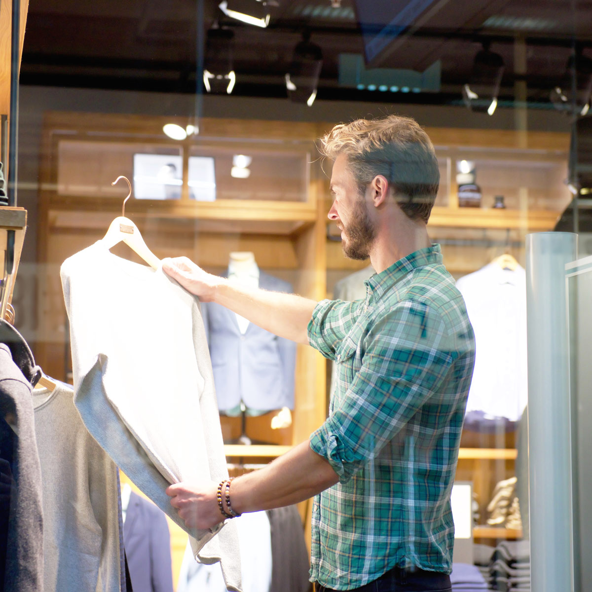 Man at a clothing store looking at a dress shirt