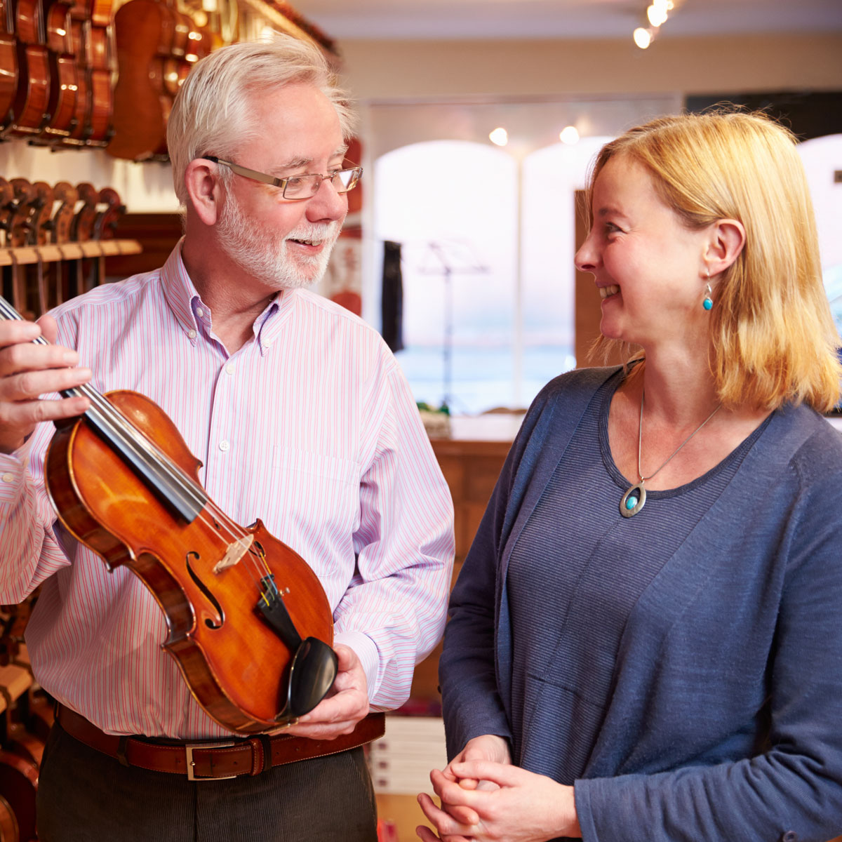 Business owners reviewing musical instrument inventory inside their store
