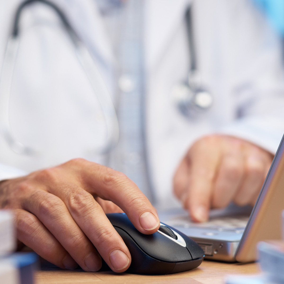 A doctor clicks on a computer mouse in search of the preauthorization tool.