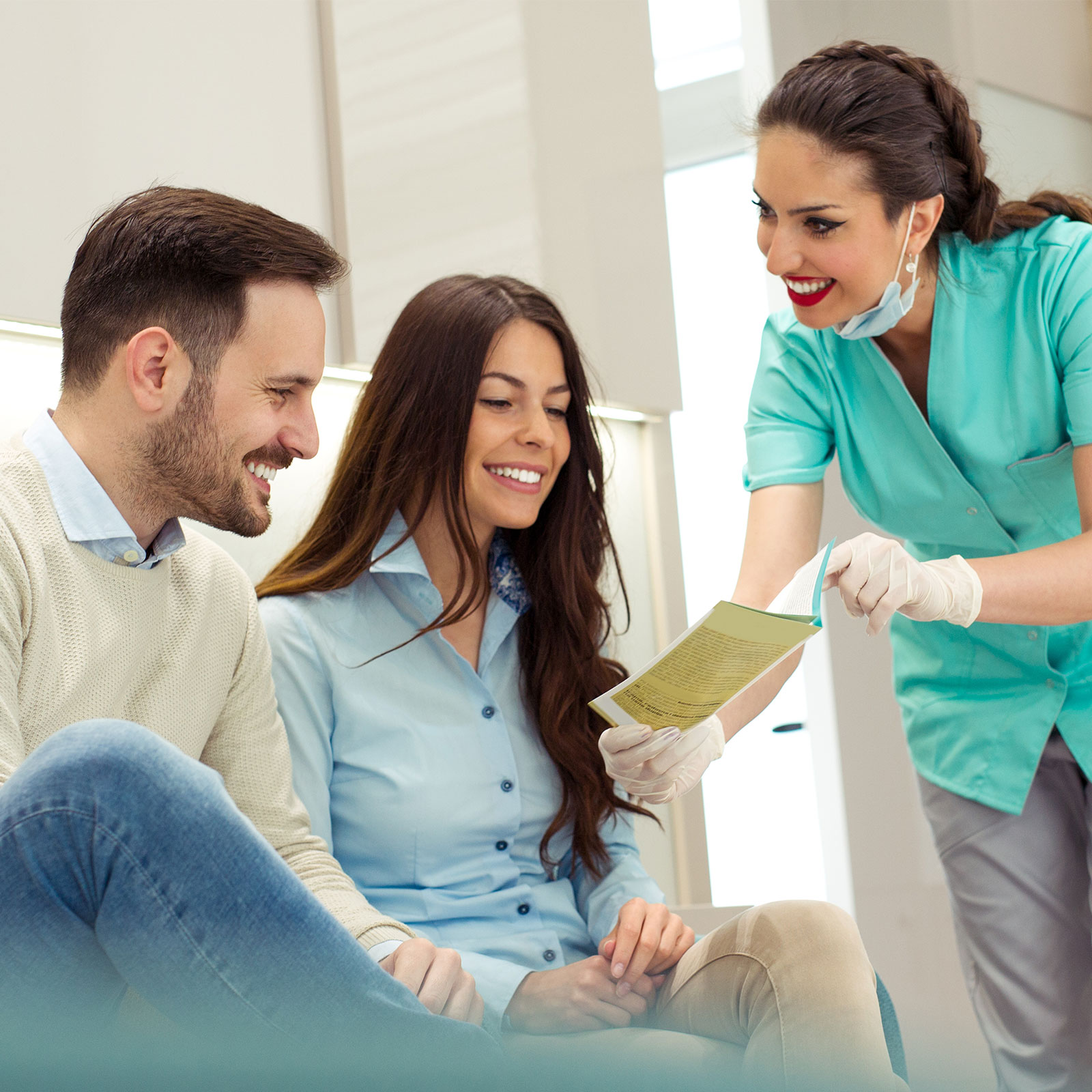 Un asistente dental explica las opciones del plan a una pareja.