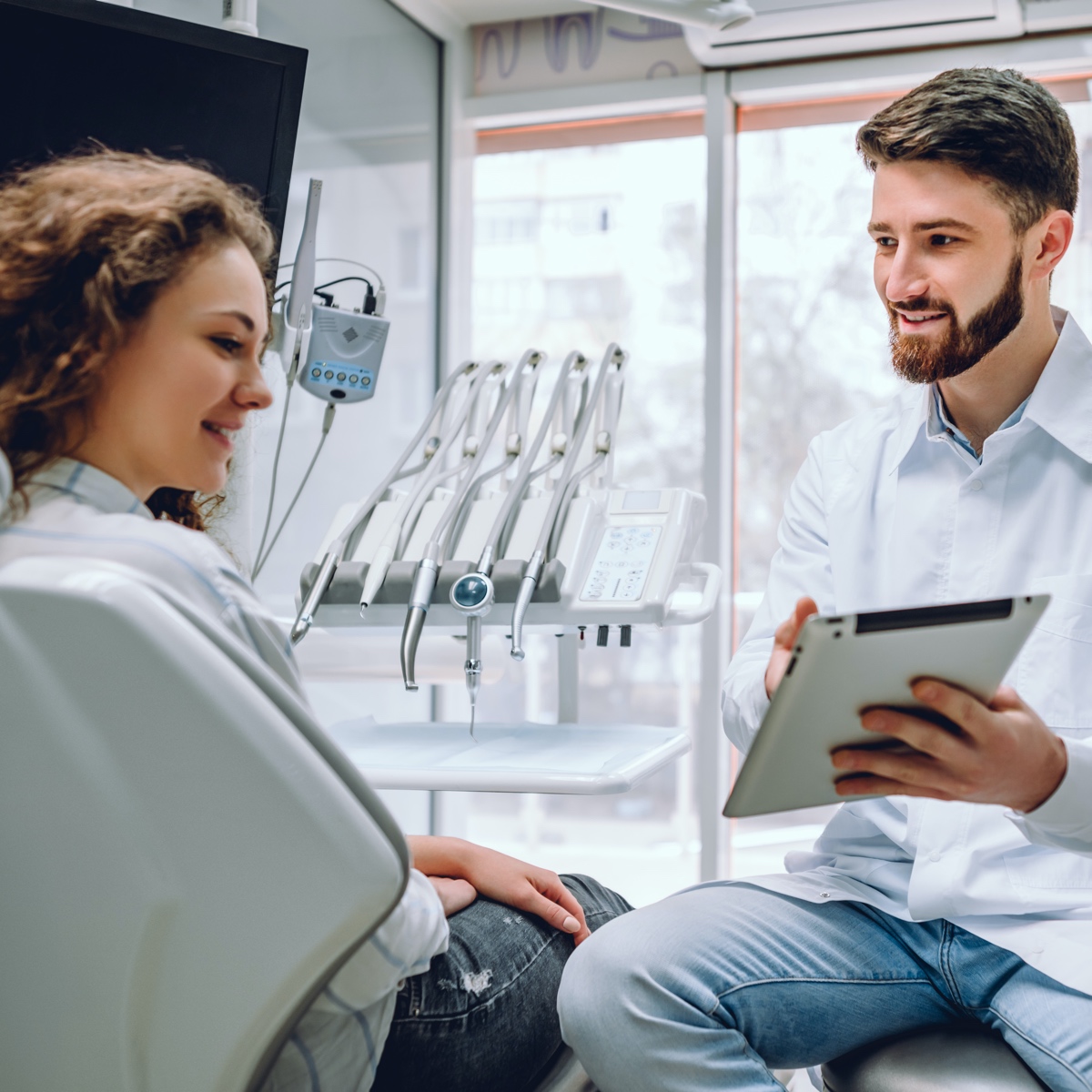 Dentista hablando con un paciente sobre el tratamiento dental