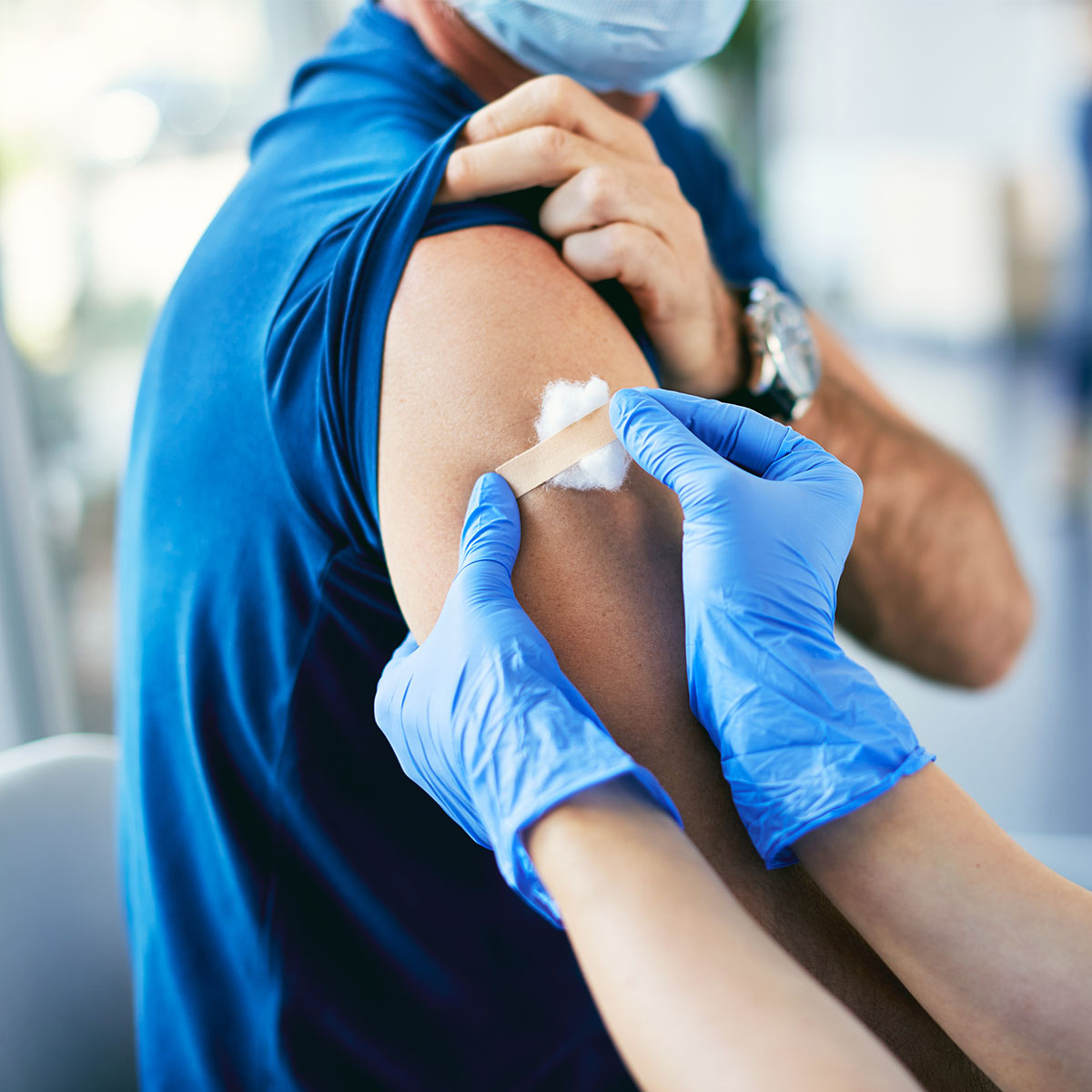 Un paciente recibe un apósito después de la vacuna.