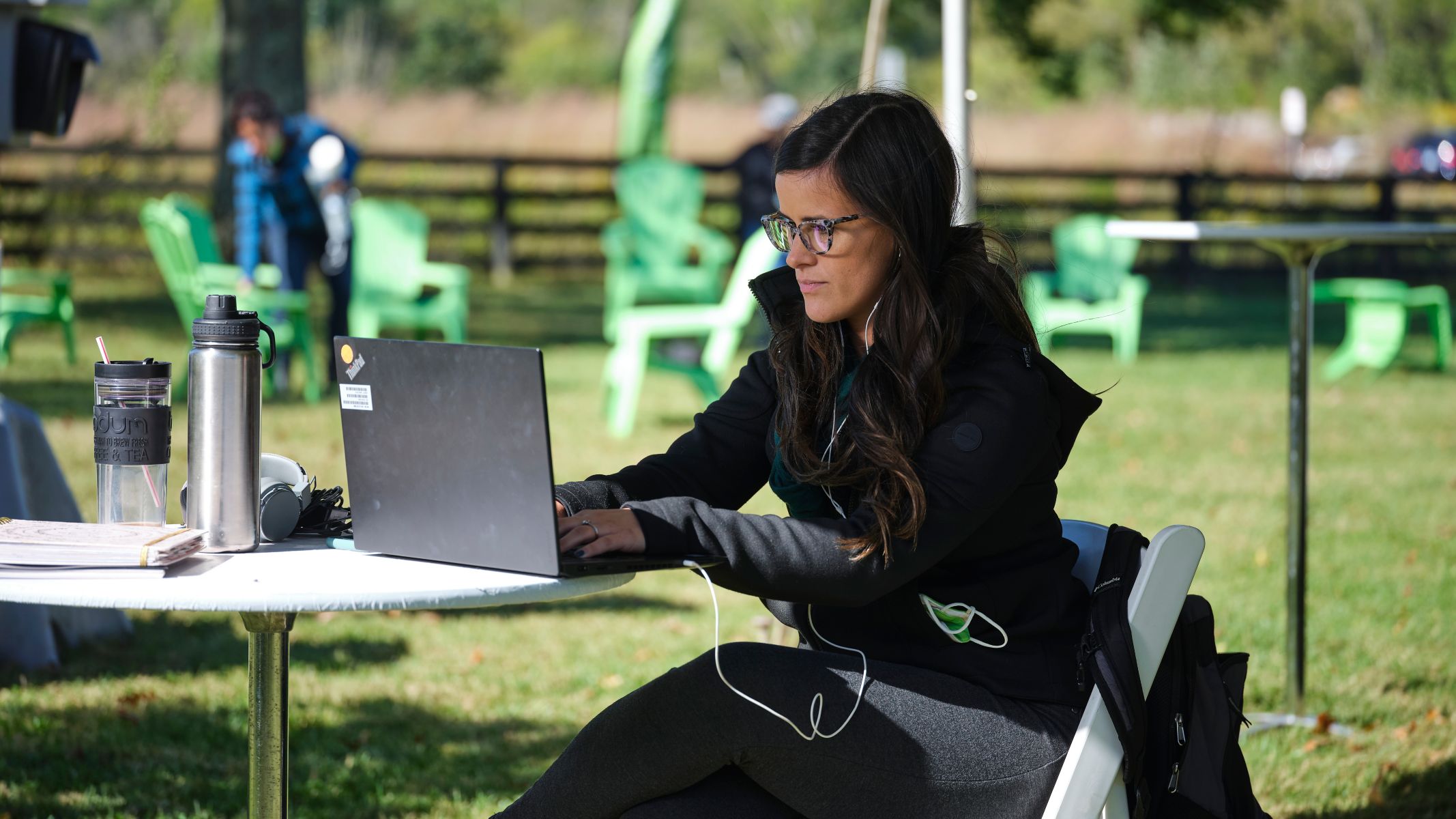 Mujer trabajando en un computador portátil en una oficina al aire libre.