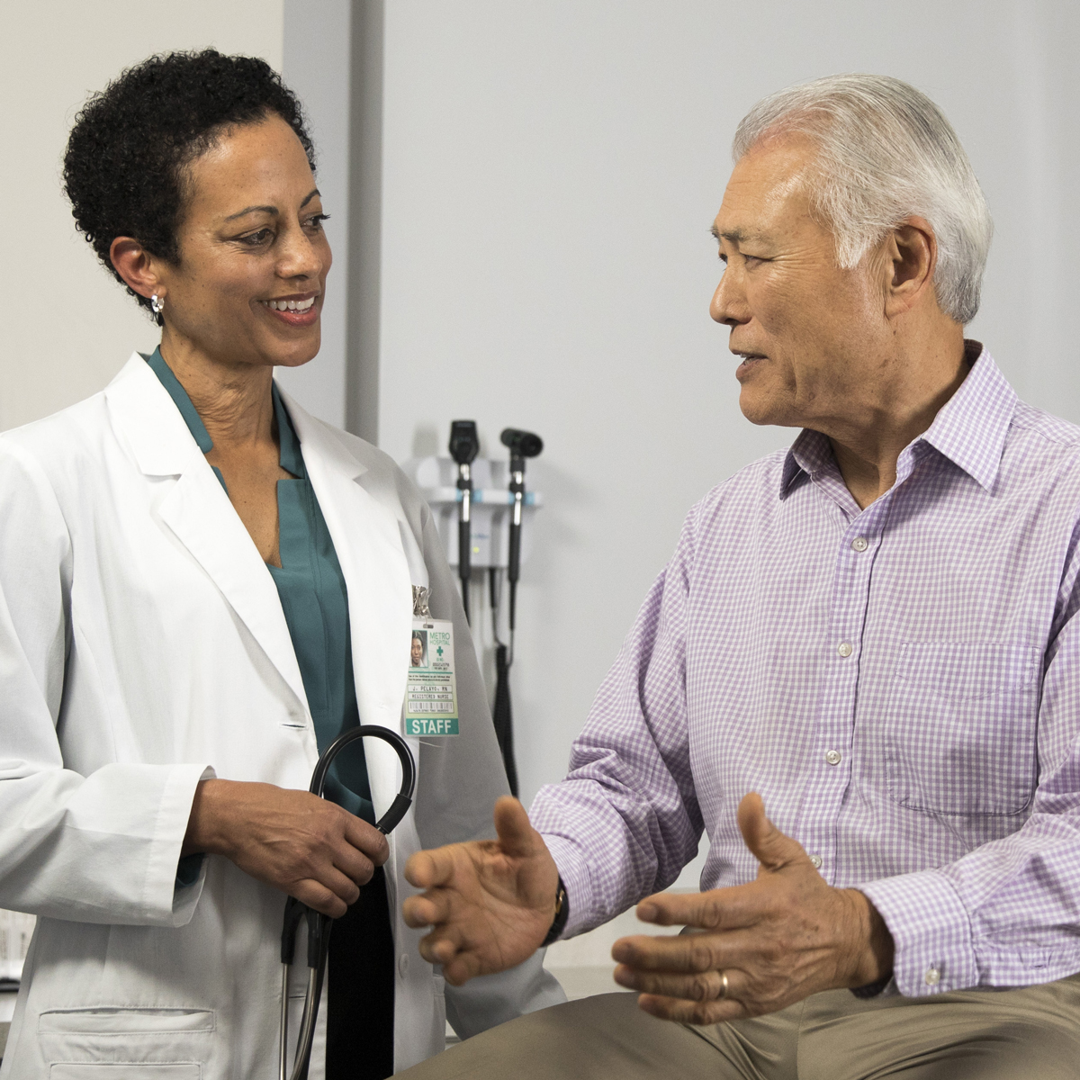 A doctor listens to a patient as he explains his symptoms.