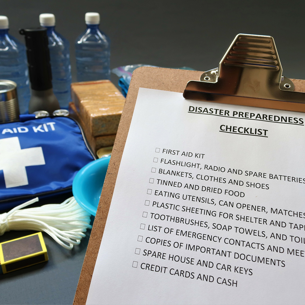 Un ejemplo de un equipo de contingencia ante catástrofes, que incluye una lista de control, un kit de primeros auxilios, alimentos enlatados y botellas de agua.