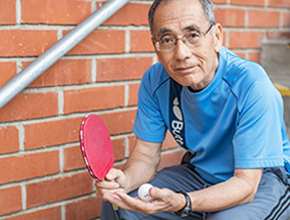 Hiro Moriyasu sosteniendo una paleta y pelota de tenis de mesa
