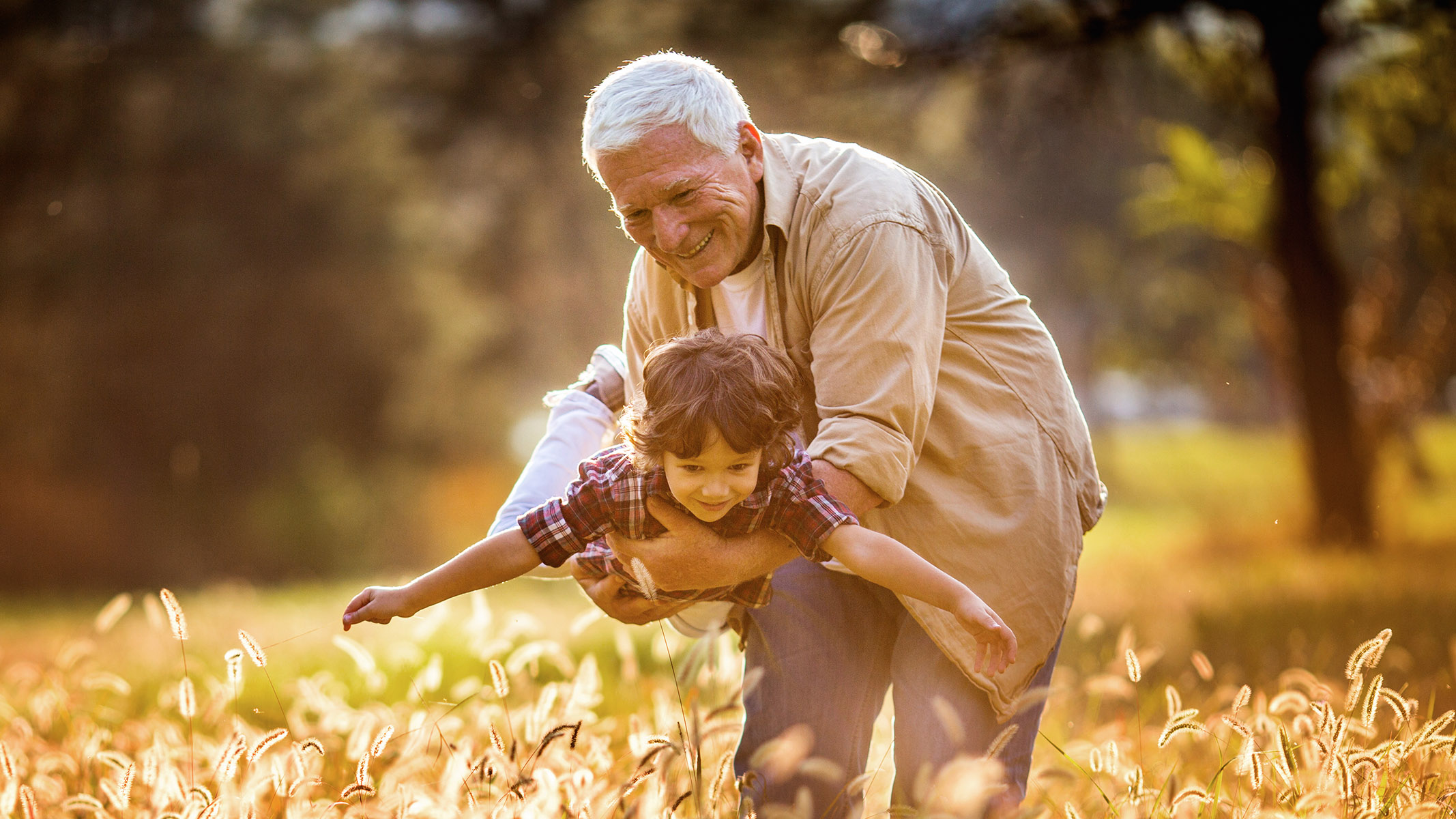 Un abuelo juega con su nieto al aire libre