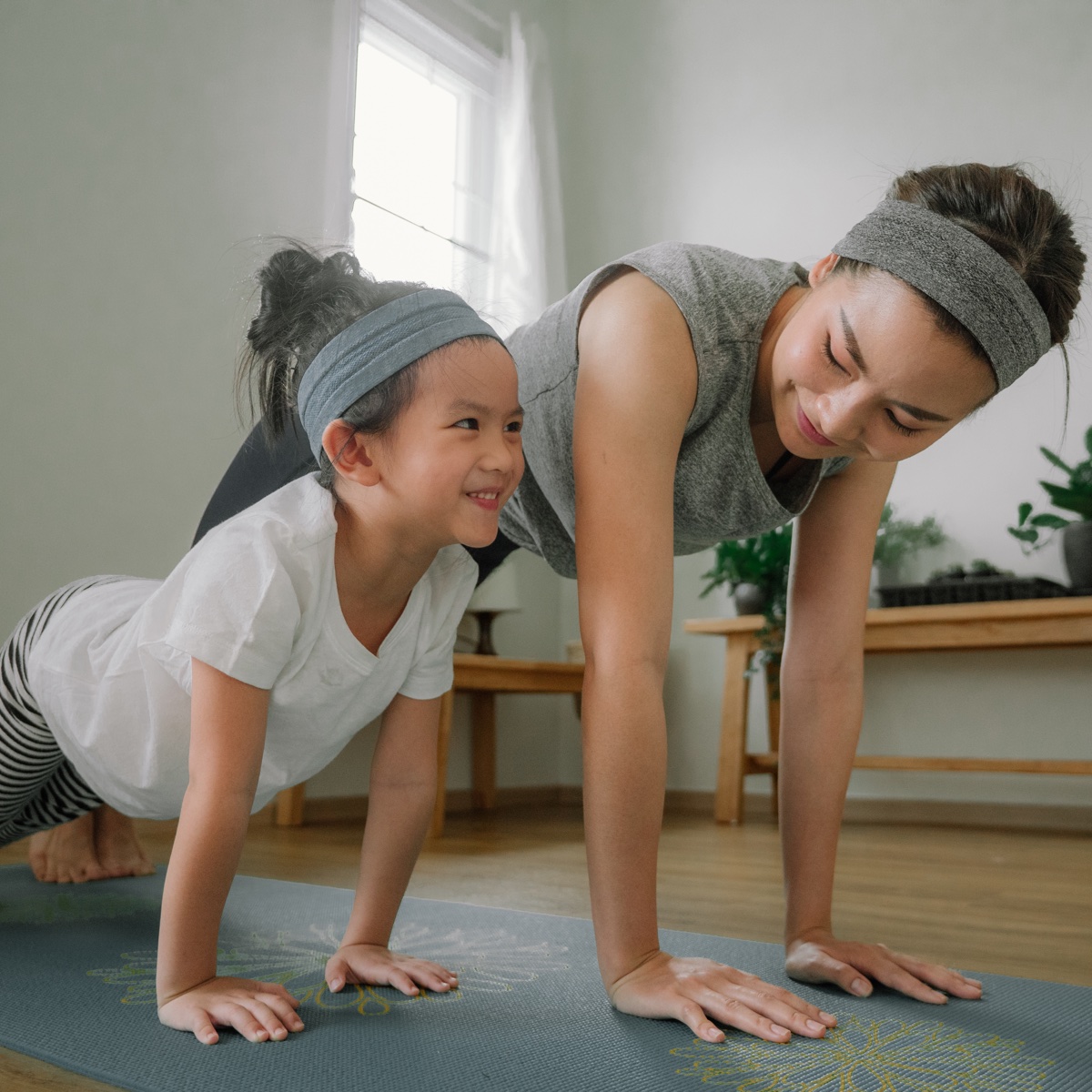 Mom and child doing mat exercises together.