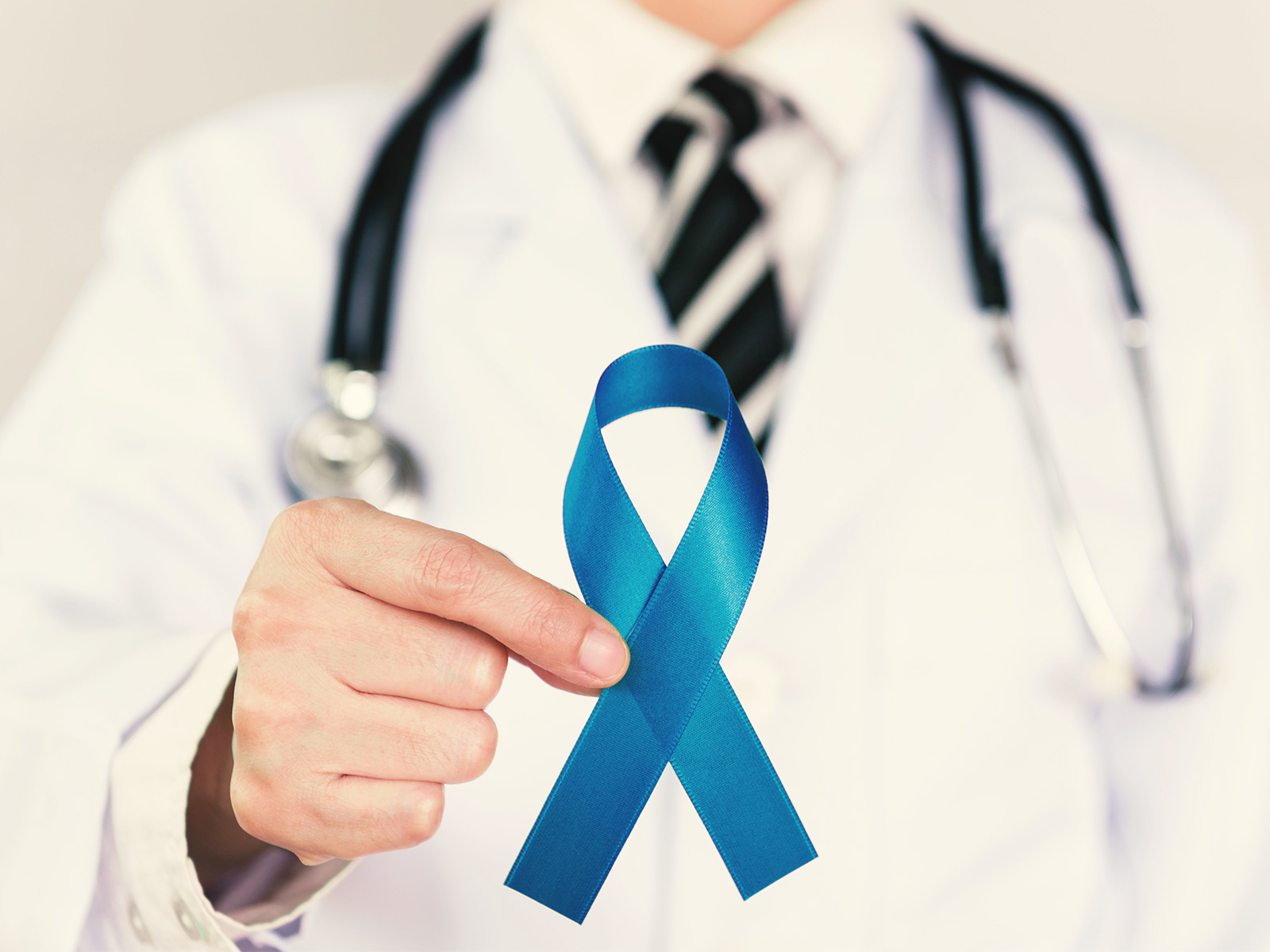 Un proveedor de Medicaid sujetando una cinta azul de concientización sobre el cáncer colorrectal