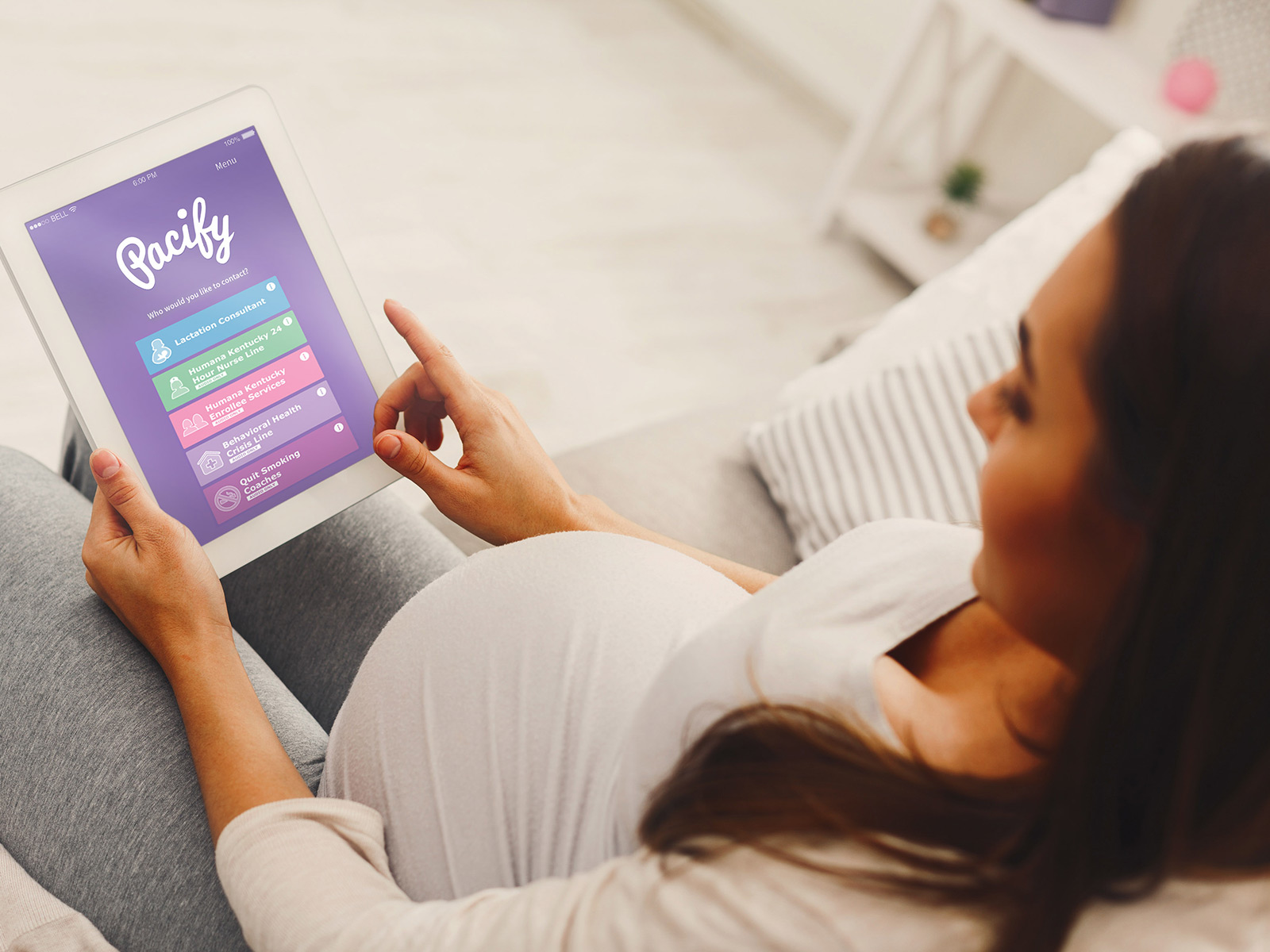 Mujer embarazada usando la aplicación Pacify en su tablet.
