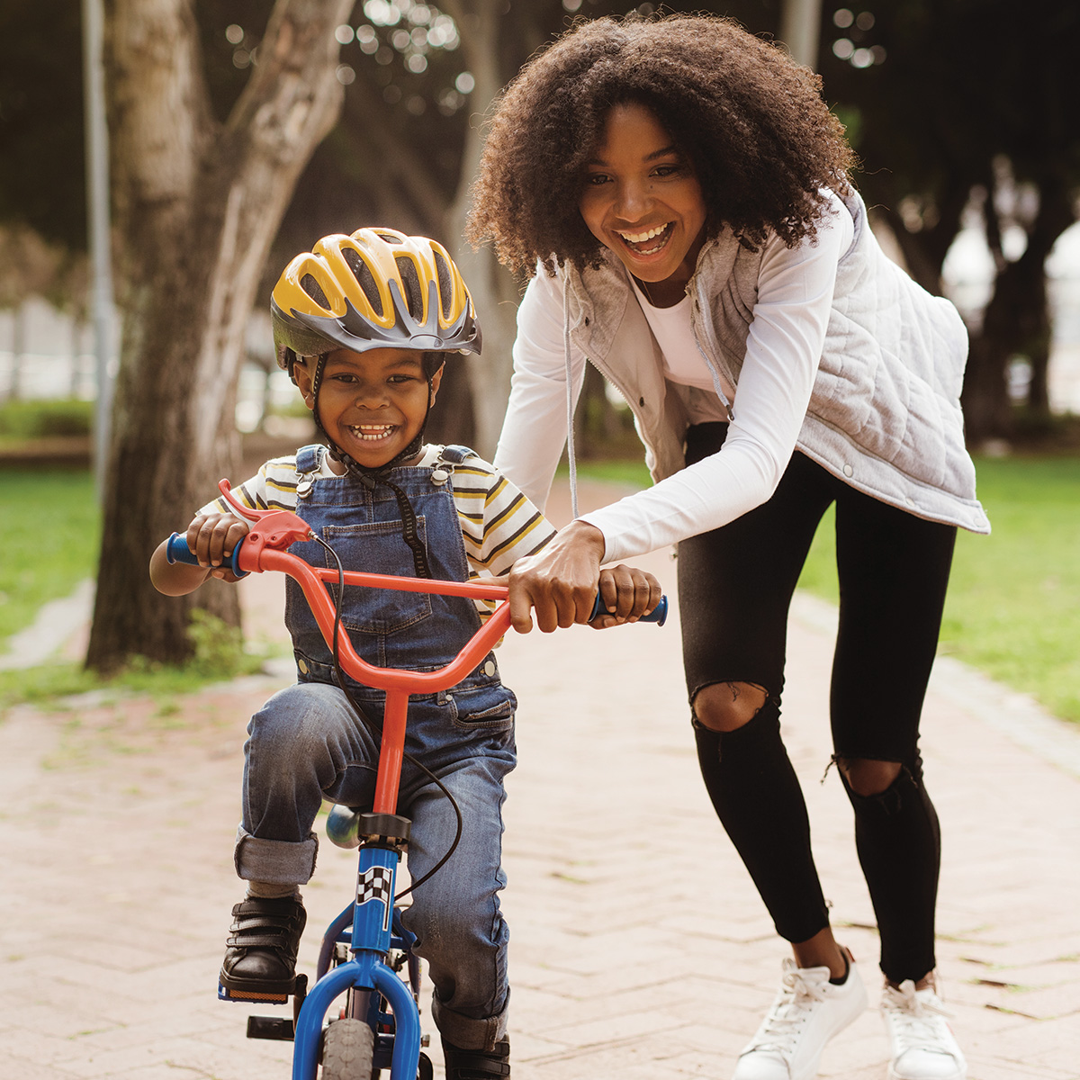 Mom helping child ride a bike