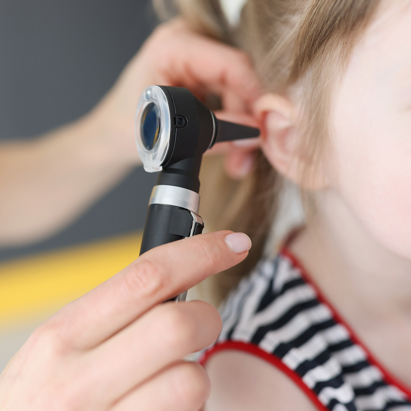 Médica de Medicaid revisándole el oído a una niña