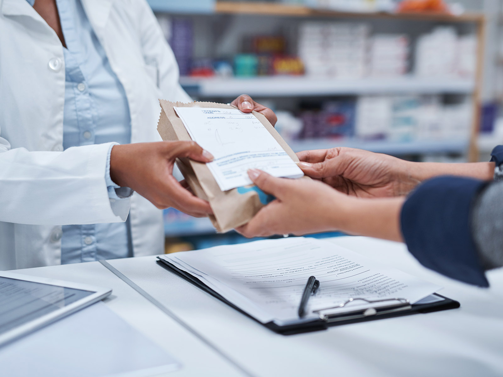 Pharmacist hands a prescription to a patient