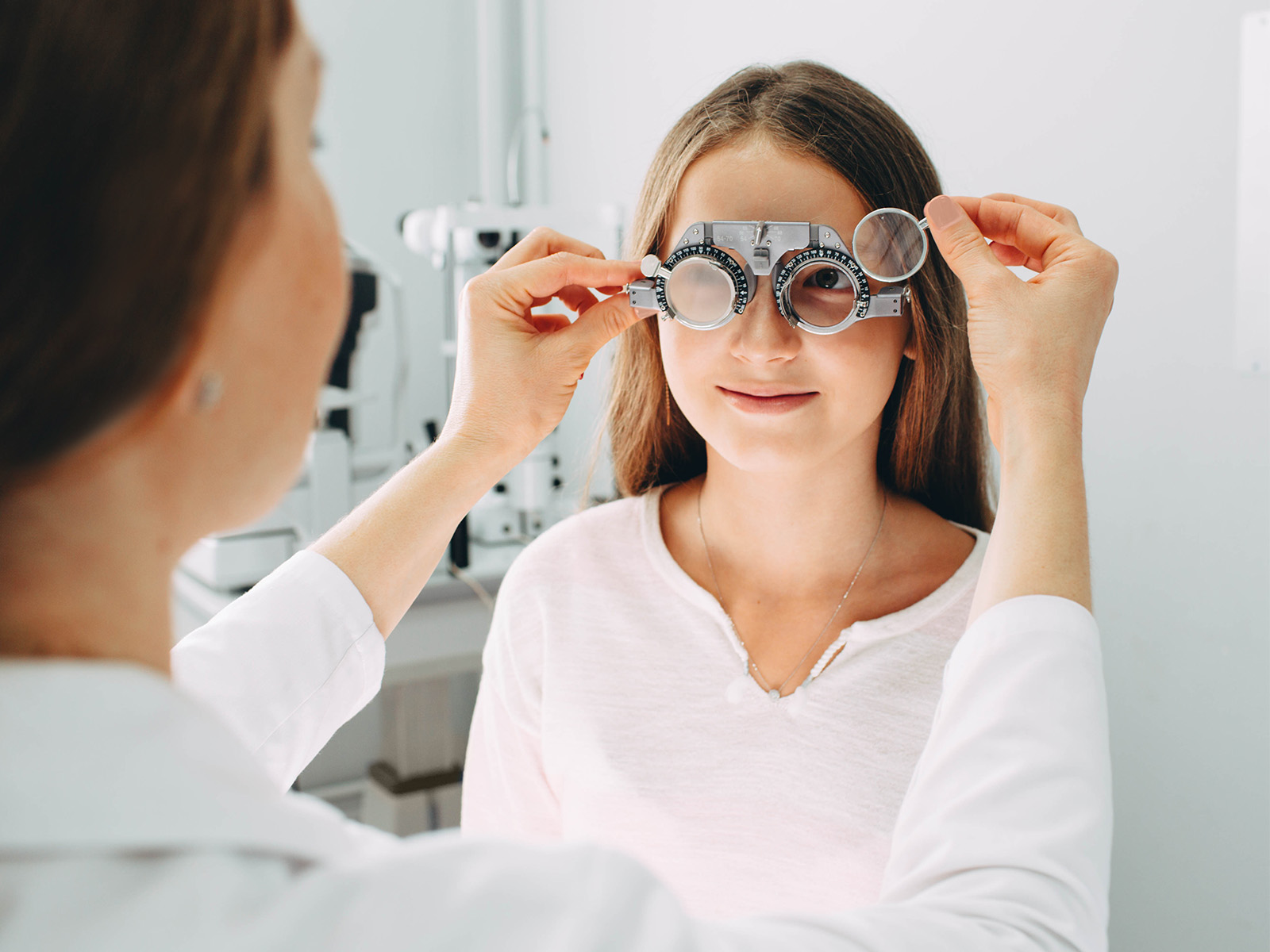 Profesional de la vista practicando un examen de la vista a una niña