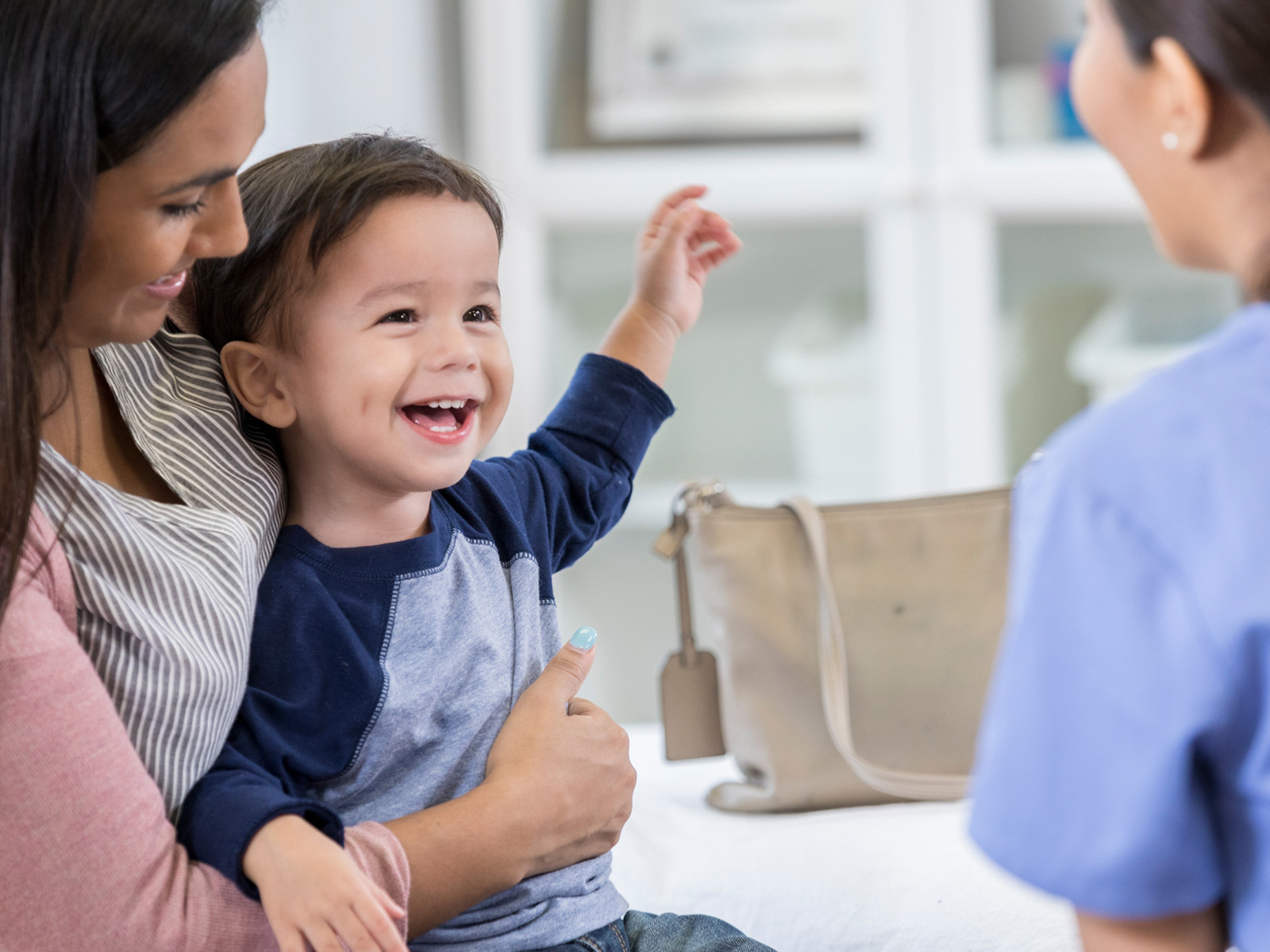 Niño sonriendo mientras su pediatra le habla