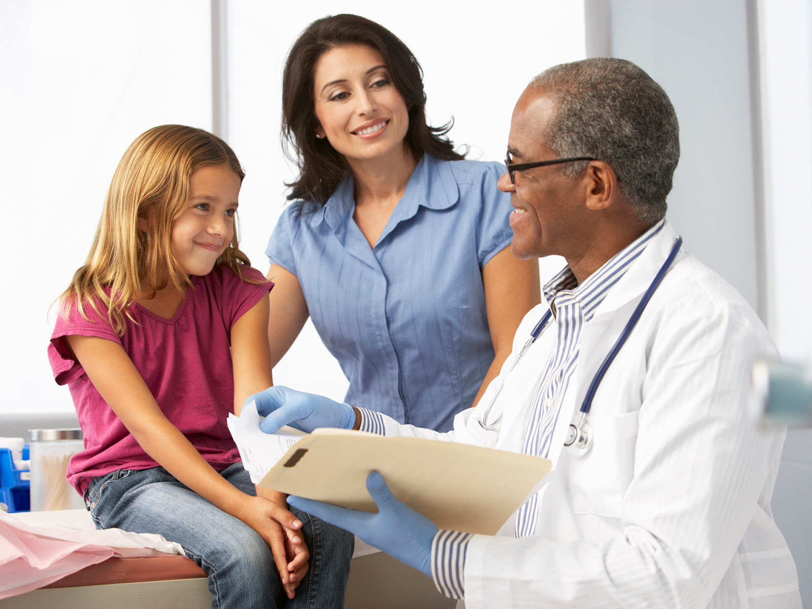 Medicaid doctor with pediatric patient and mom
