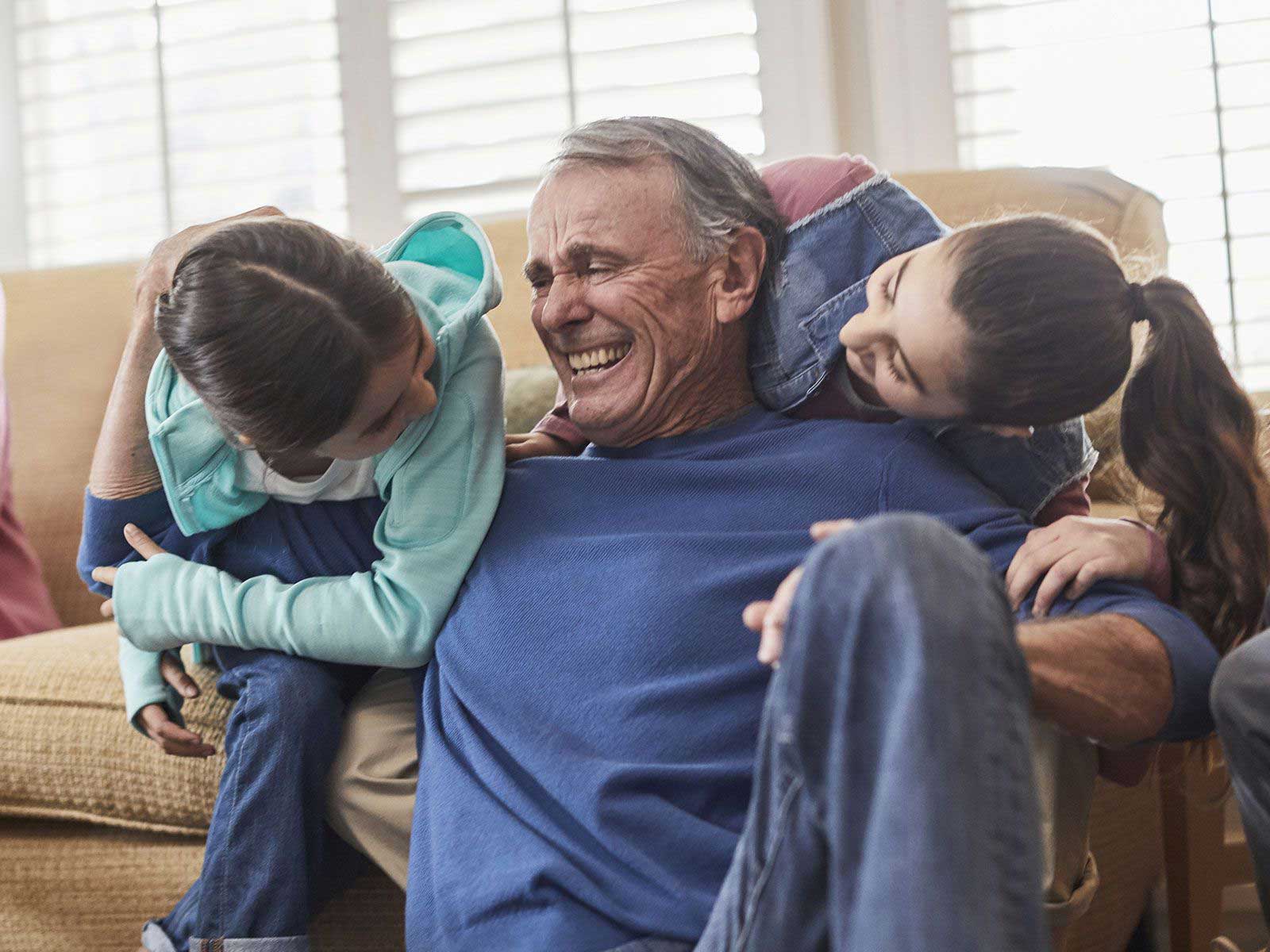 Un abuelo hace planes con sus 2 nietos en el sofá
