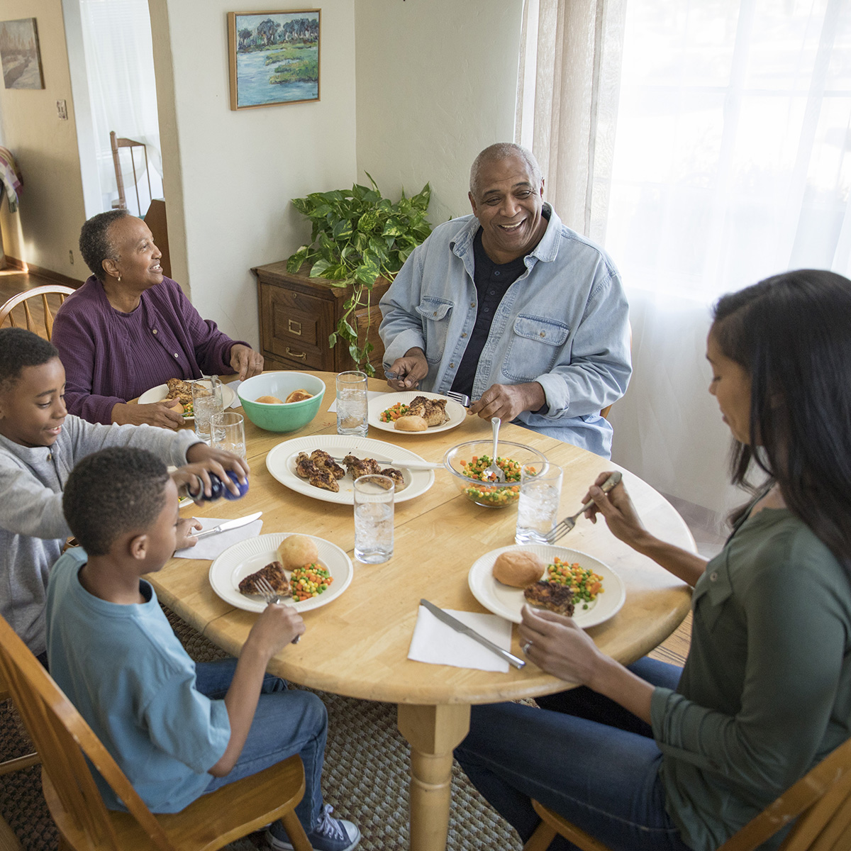 Familia reunida alrededor de la mesa disfrutando una cena agradable.