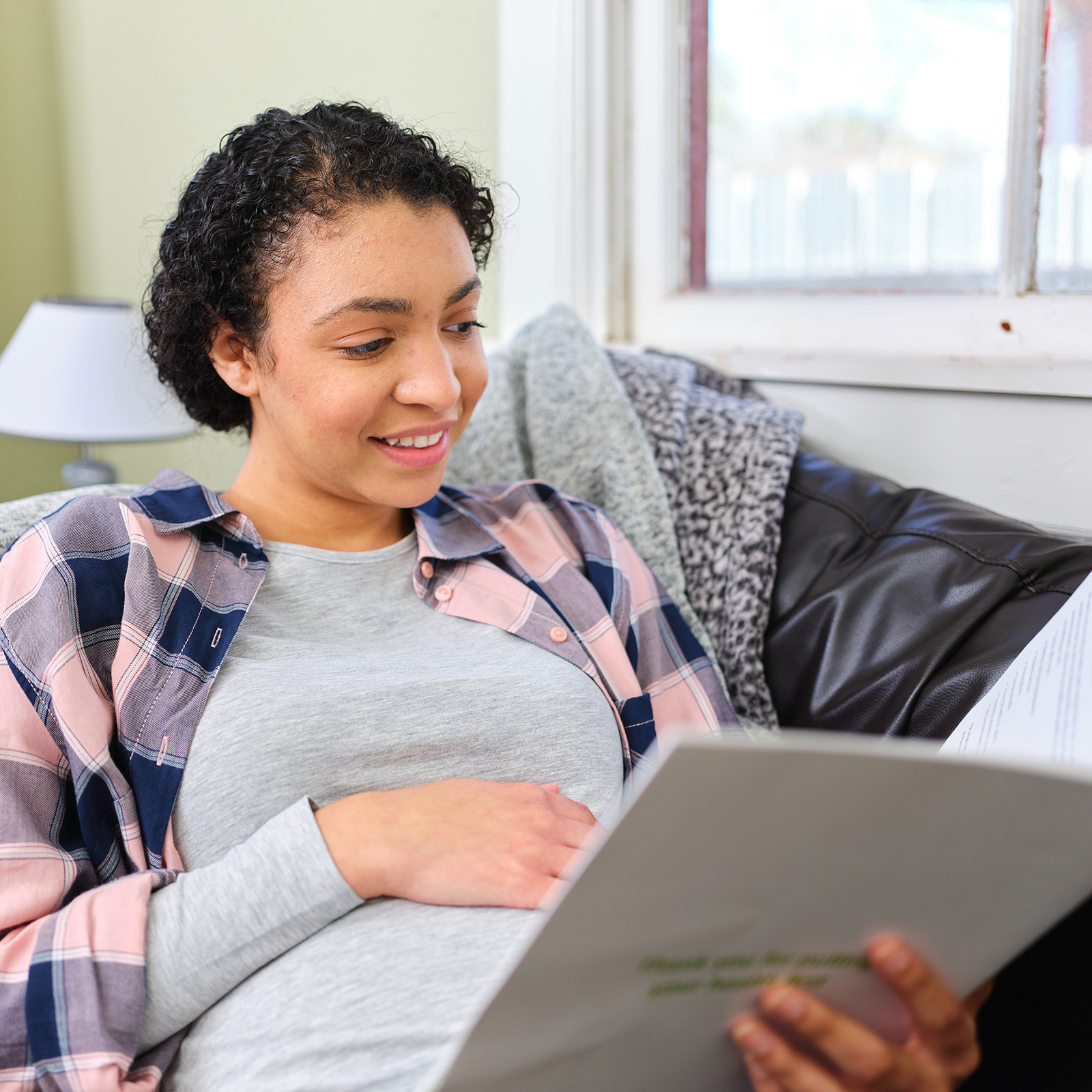 Mujer embarazada leyendo papeles