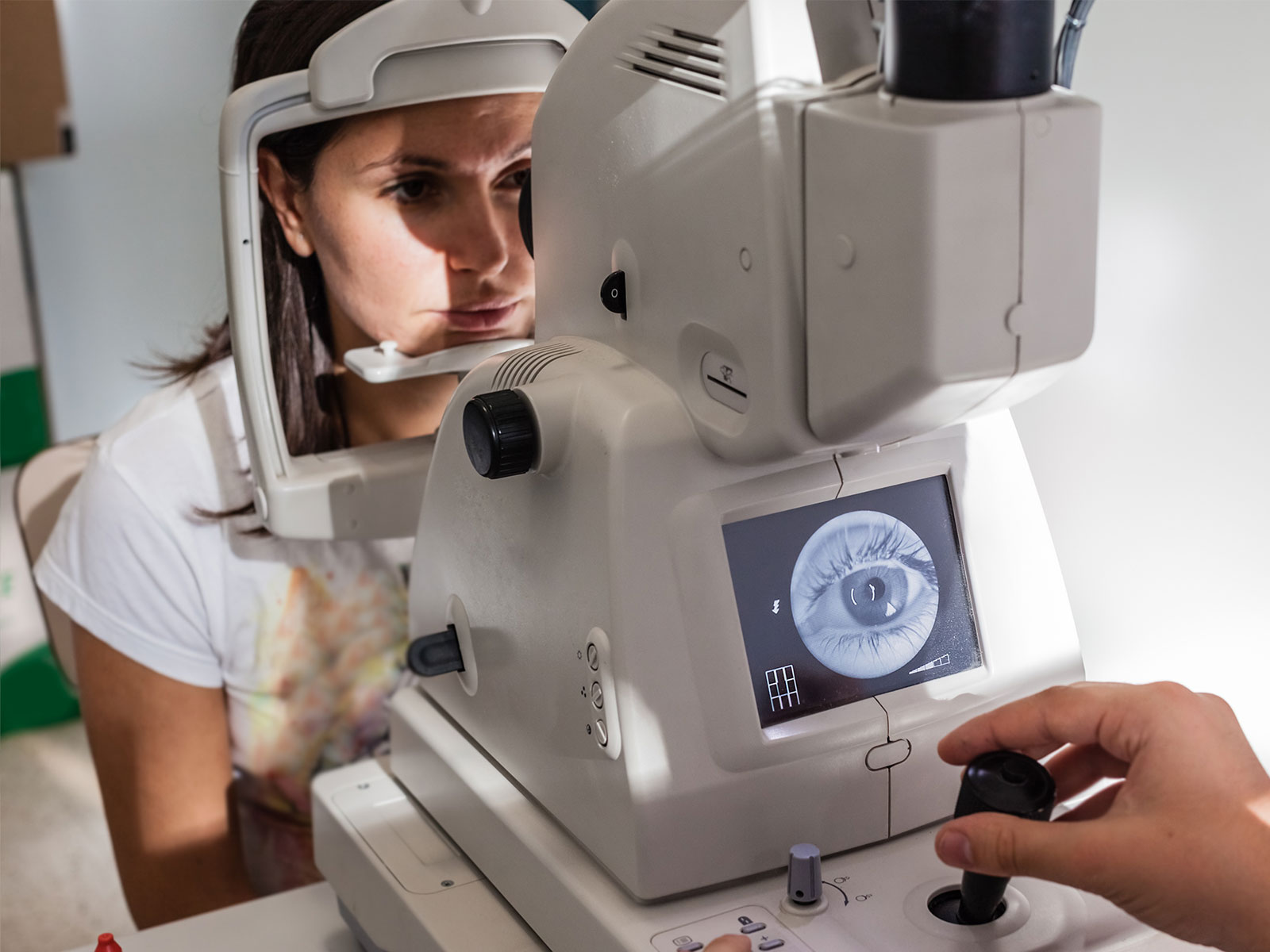 woman looking into a retinal camera during an eye exam